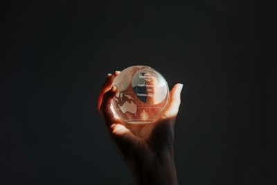 A person holding a glass globe in their hand.