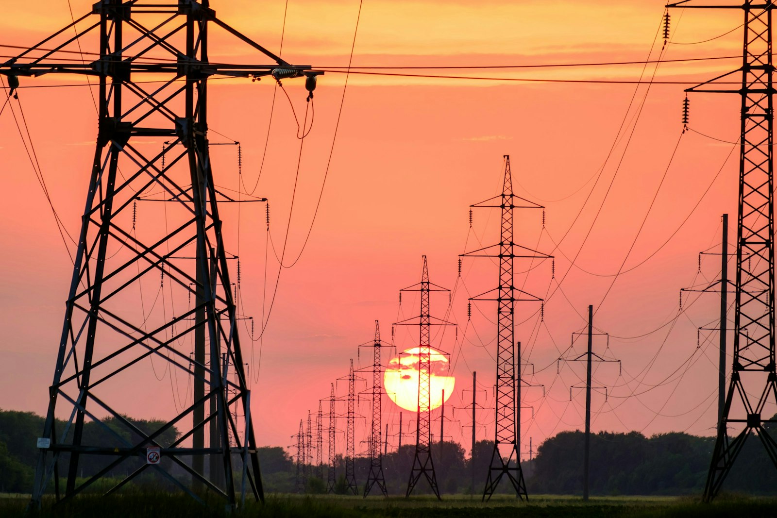 Silhouette of electric post during sunset.