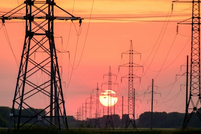 Silhouette of electric post during sunset.