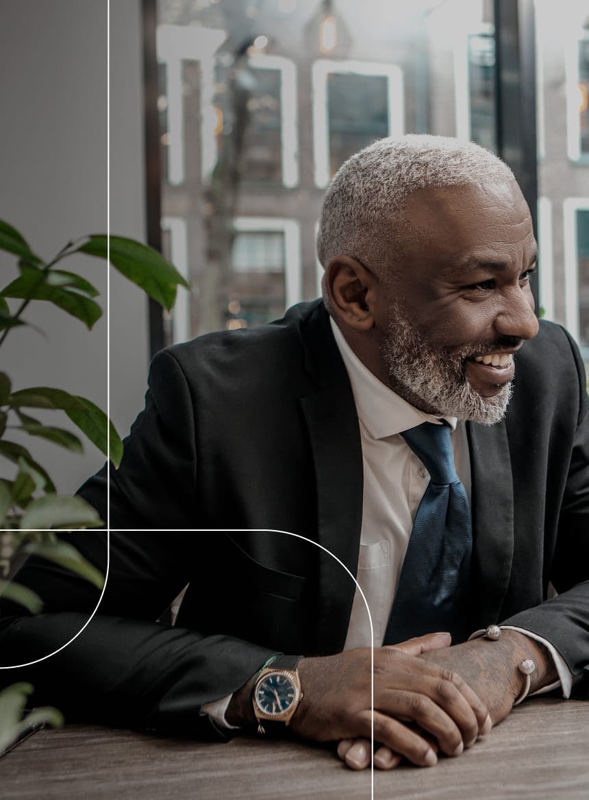 older man sitting at a table, smiling