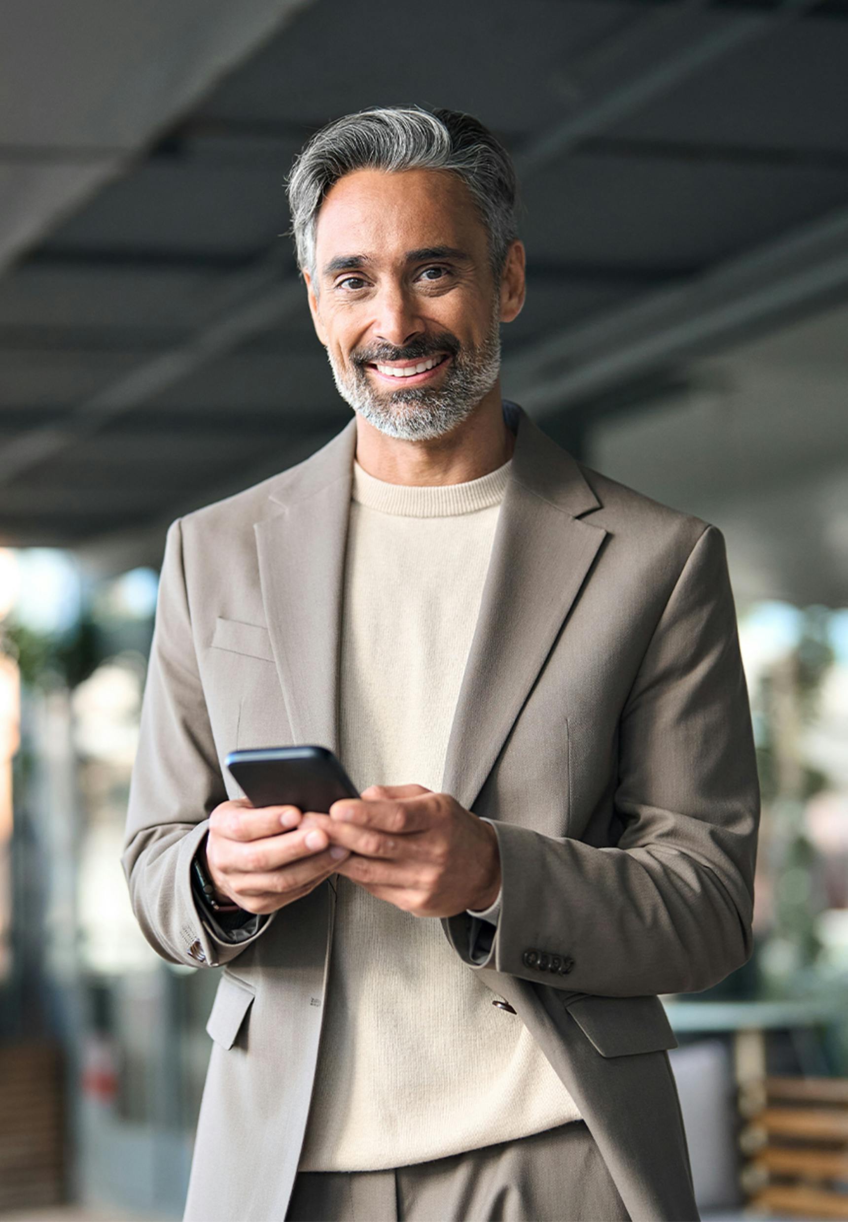 man smiling, holding his phone