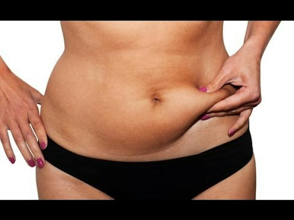 Woman pinching fat in midriff