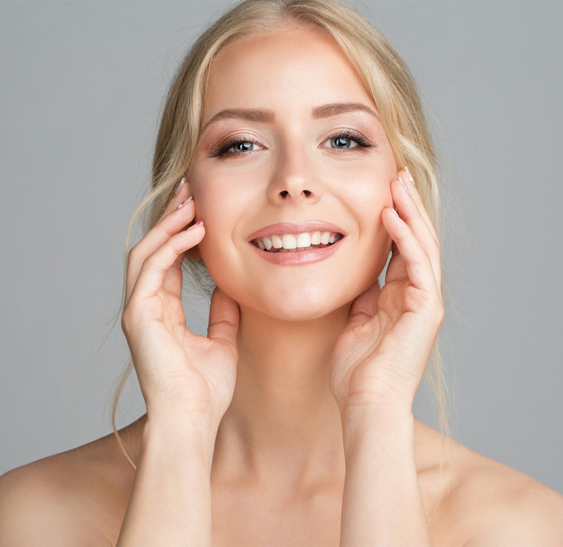 woman smiling and touching the sides of her face