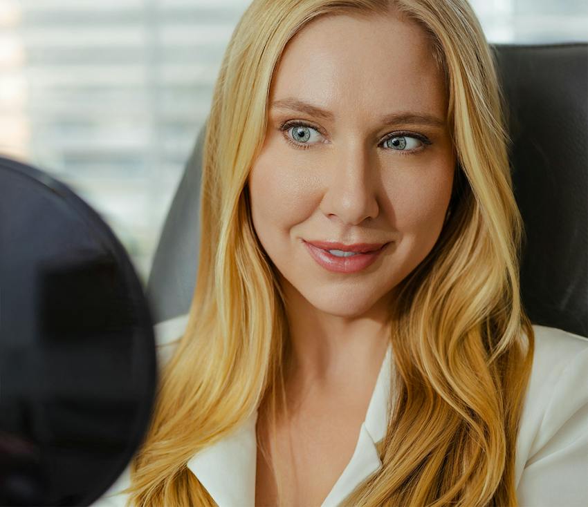 woman with blonde hair looking at herself in a mirror