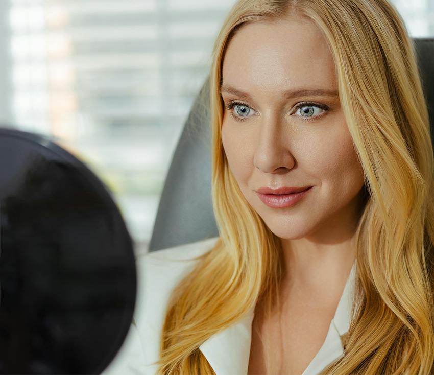 Woman with long blonde hair and blue eyes in white blazer