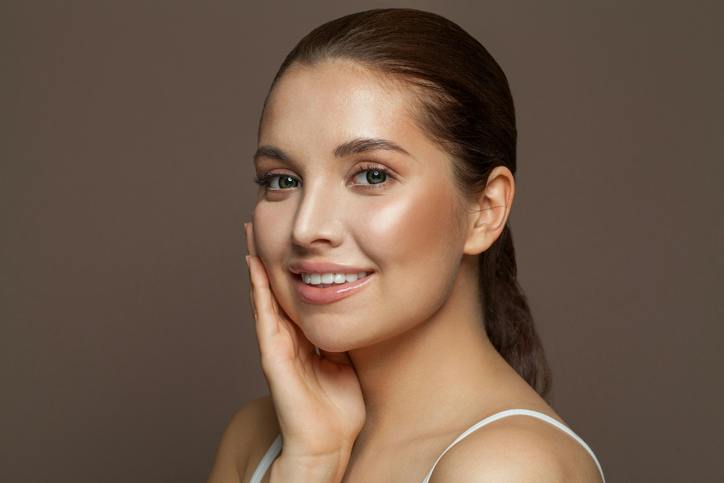 woman smiling and resting her hand on her cheek