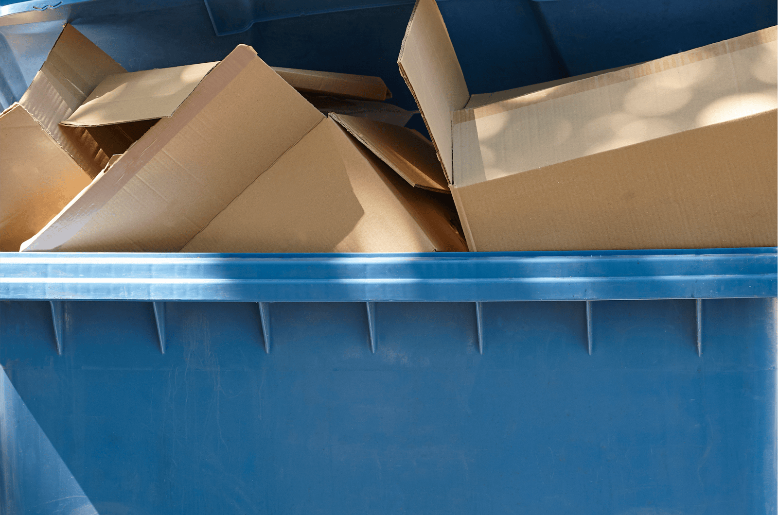 A blue bin filled with brown cardboard boxes.