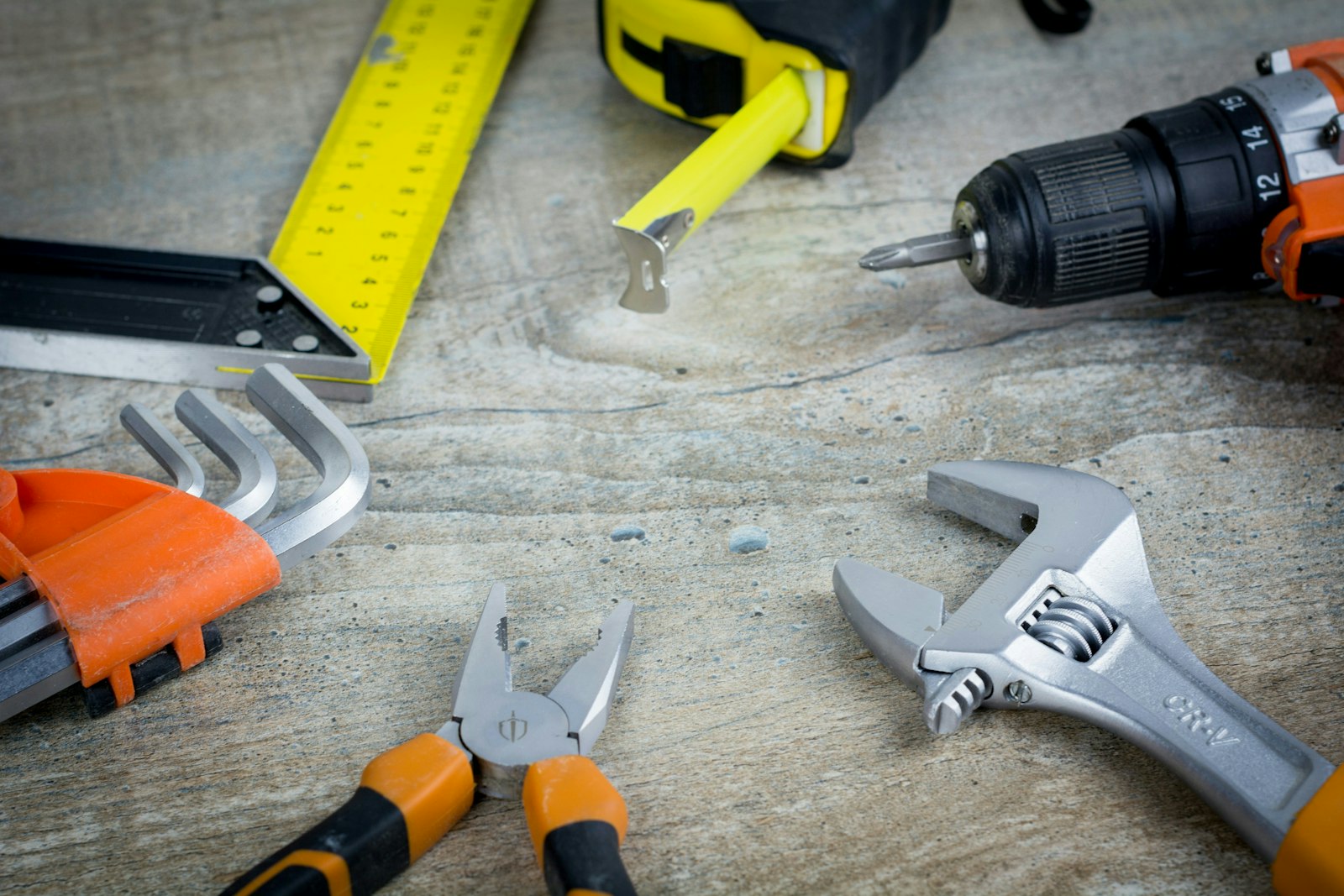 Yellow and orange tools lie on a wood background.