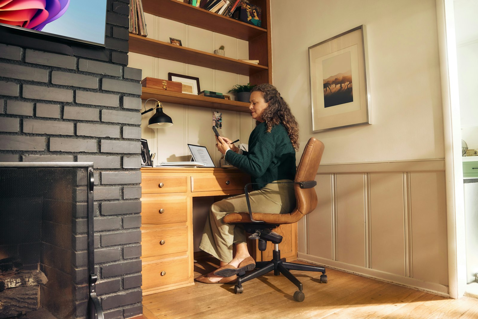 Woman behind her desk using her phone