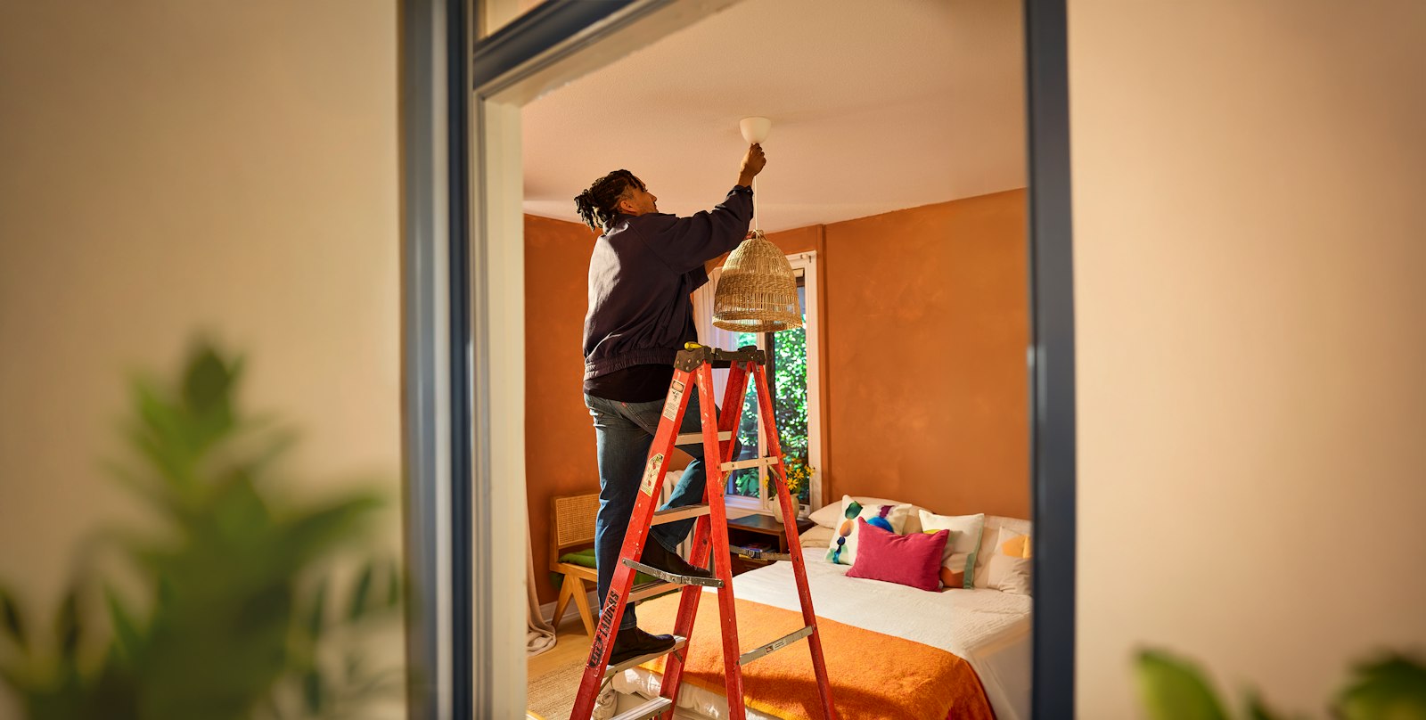 Pro standing on a ladder fixing a light