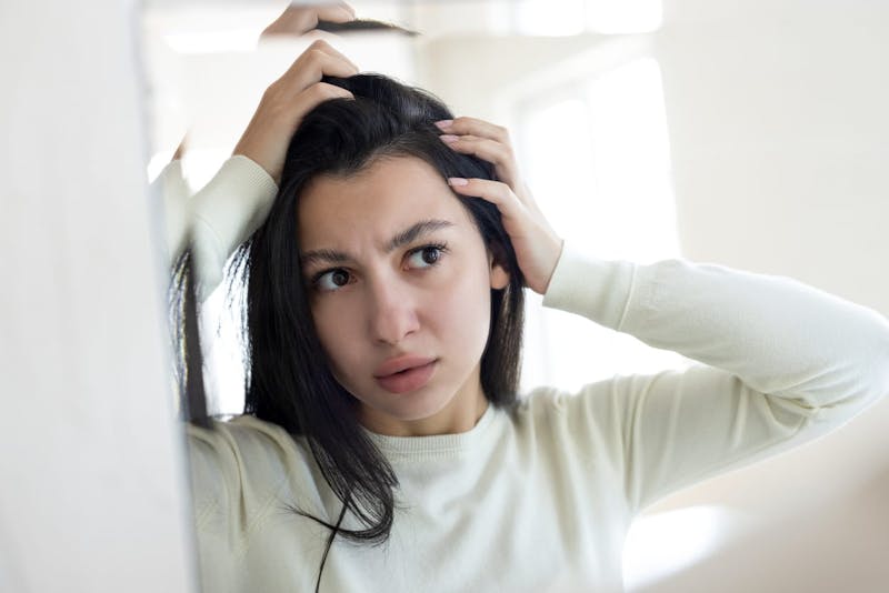 woman looking at her hair