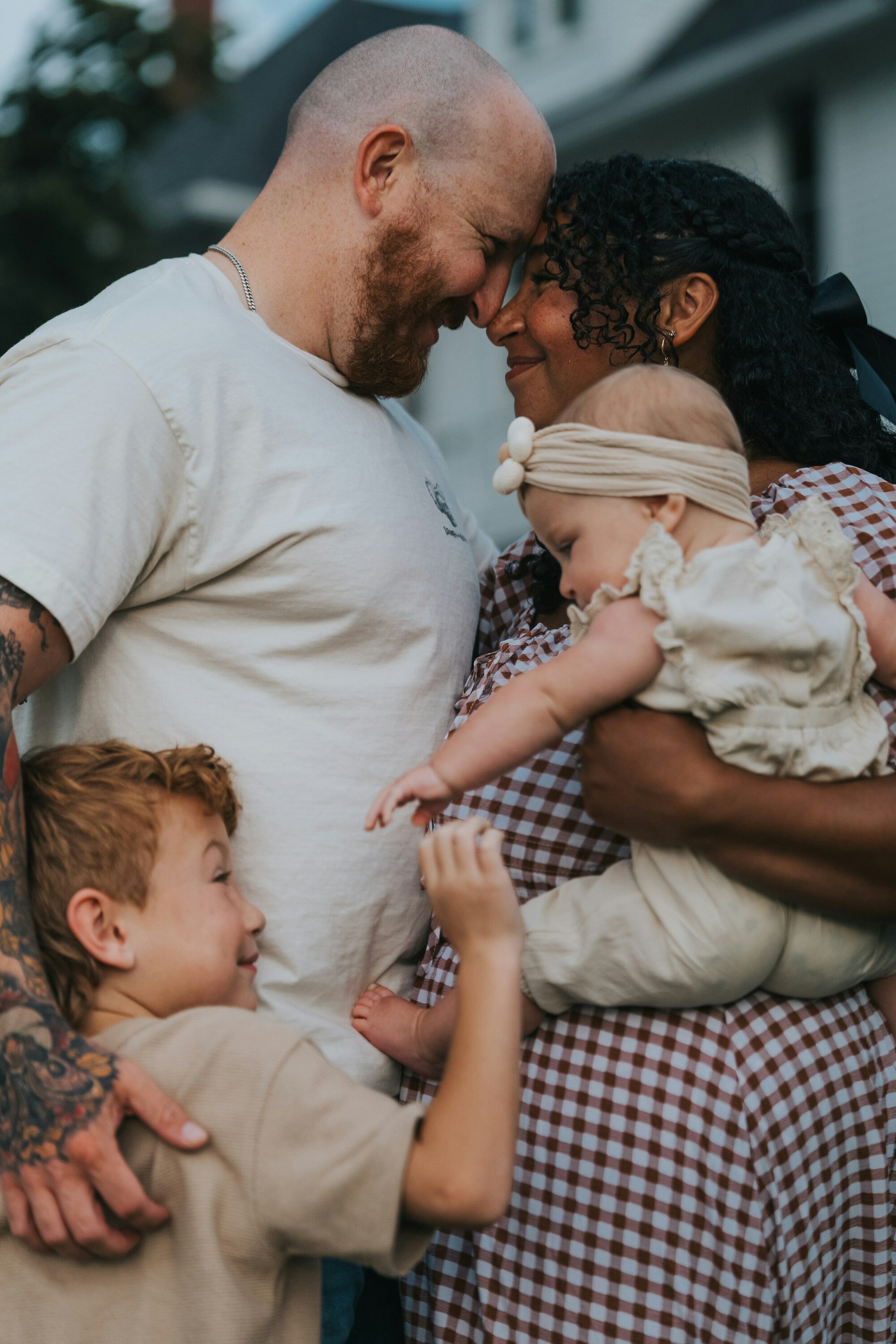 Parents forehead to forehead holding their baby, son hugging dad at Veterans Memorial Park in Avon Lake, Ohio