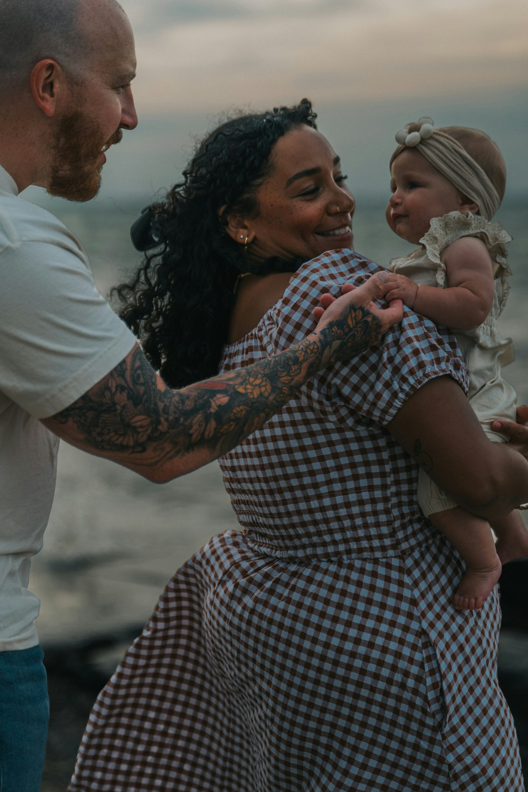 Parents dancing with their baby on the Lake Erie shore at Veterans Memorial Park in Avon Lake, Ohio