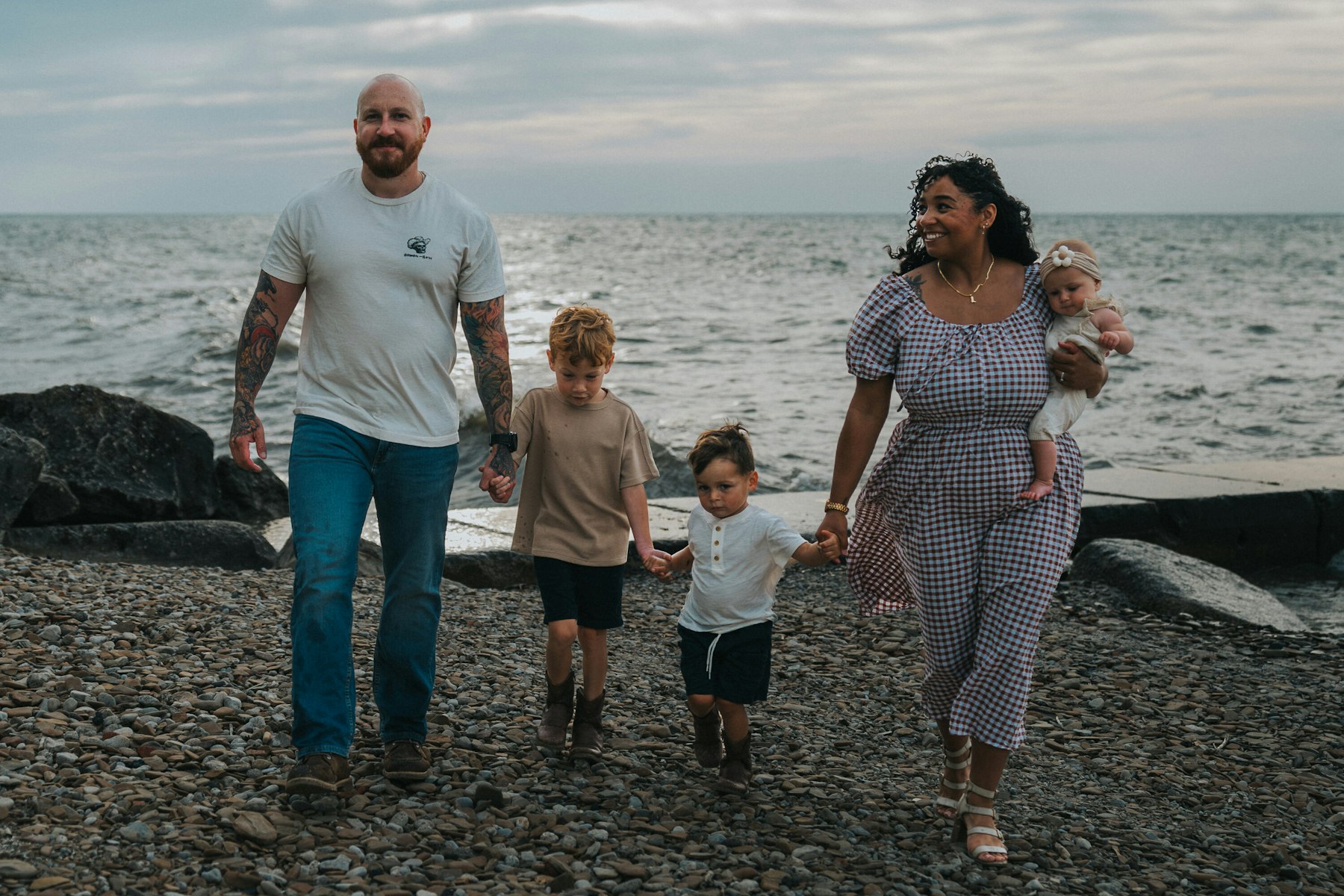 Family walking hand in hand along the rocky Lake Erie shoreline at Veterans Memorial Park in Avon Lake, Ohio
