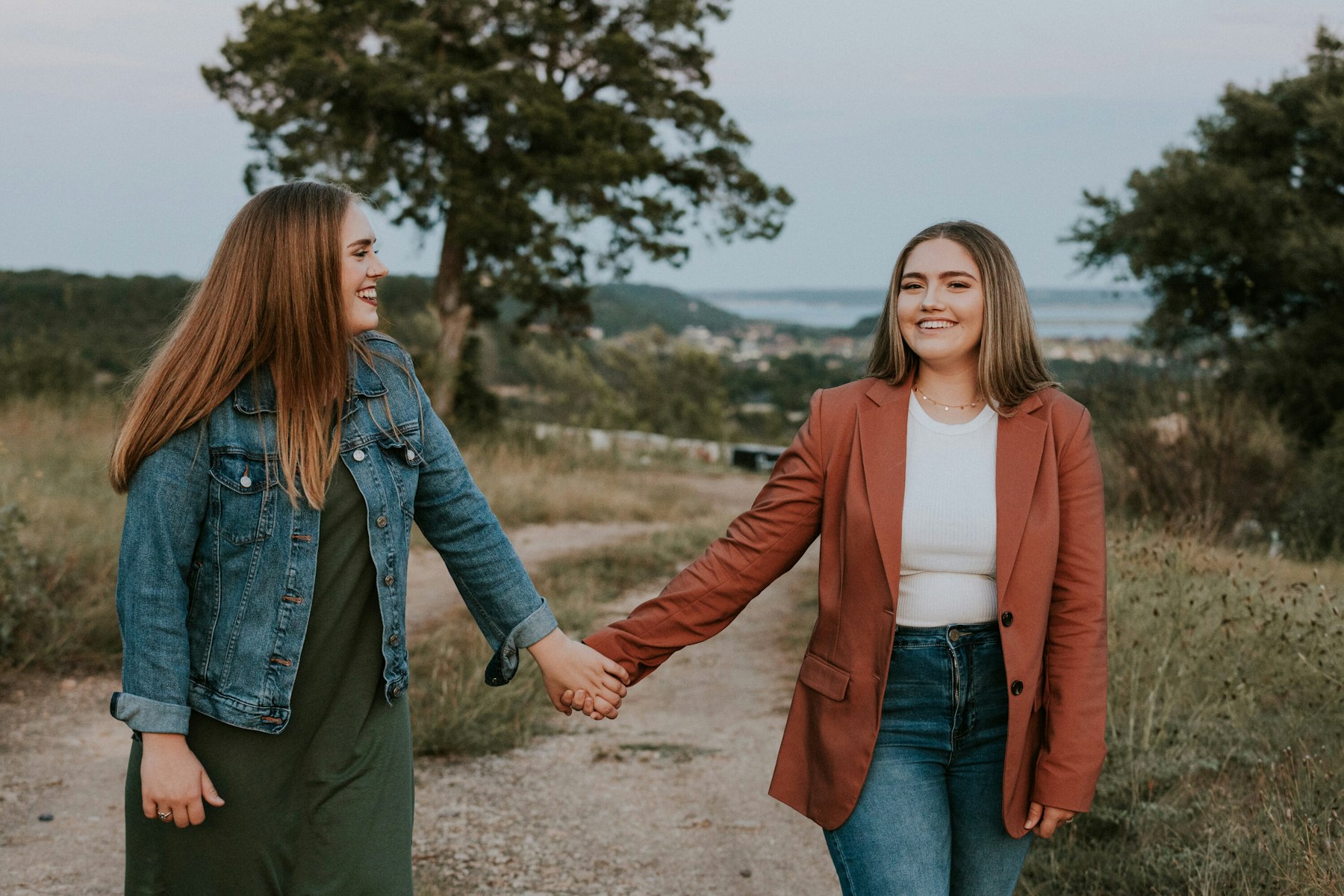 Mom and teenage daughter holding hands on the trail during a golden hour family session