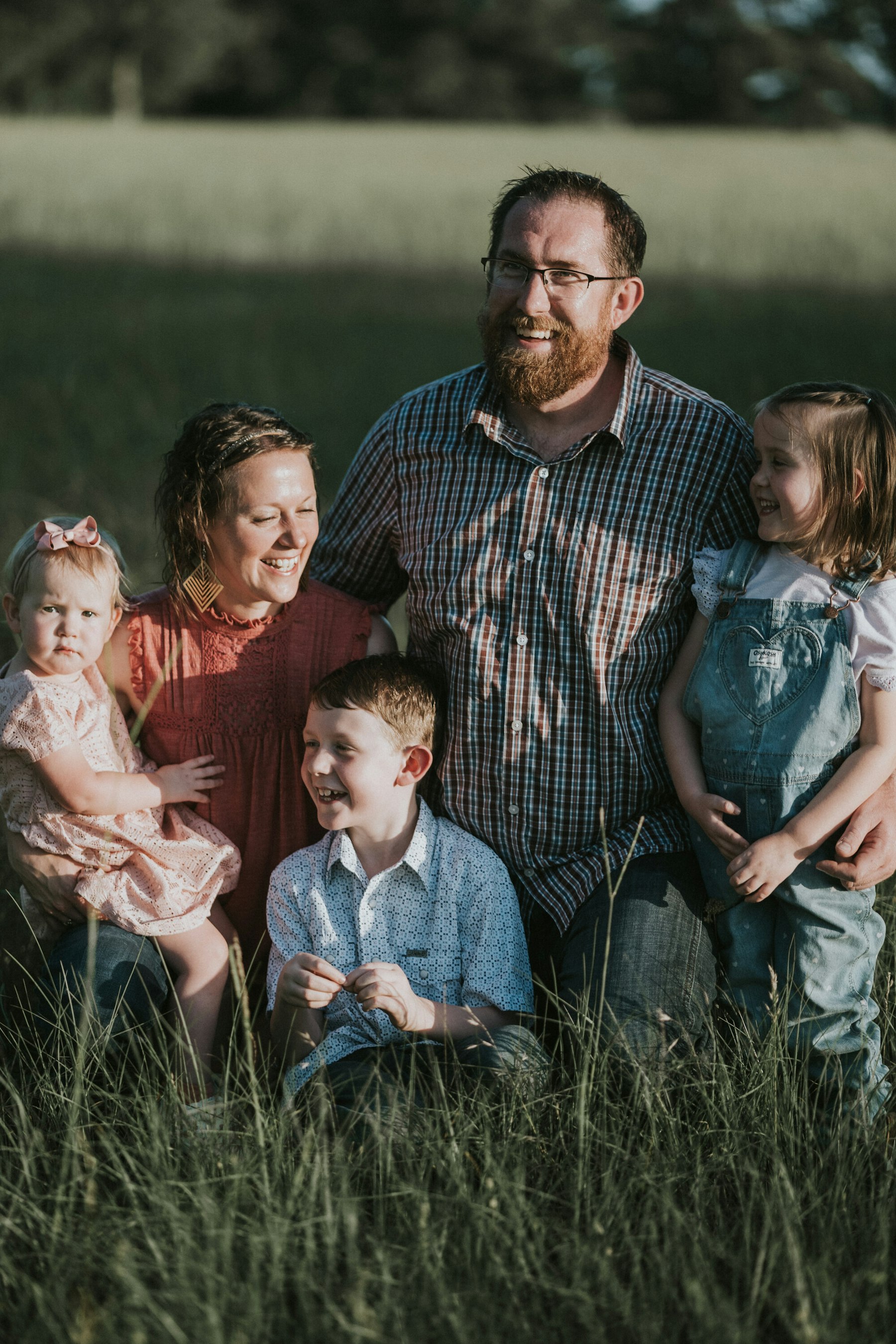 Family of five gathered in the field, mom holding the baby during a summer family session in a meadow