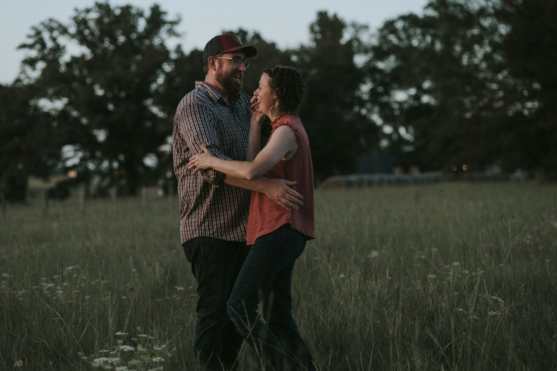 Parents dancing together in the field during a summer family session in a meadow