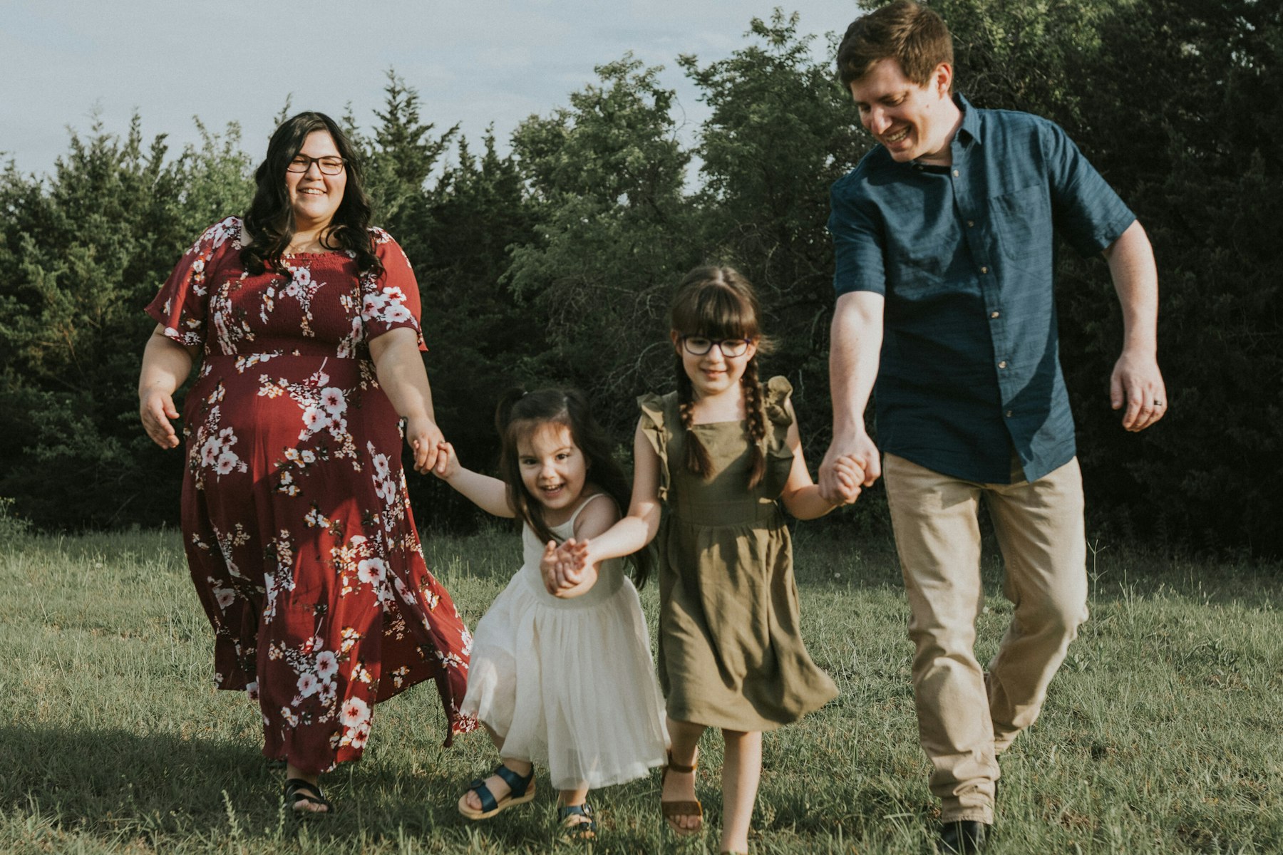 Family walking hand in hand through the field during a family session