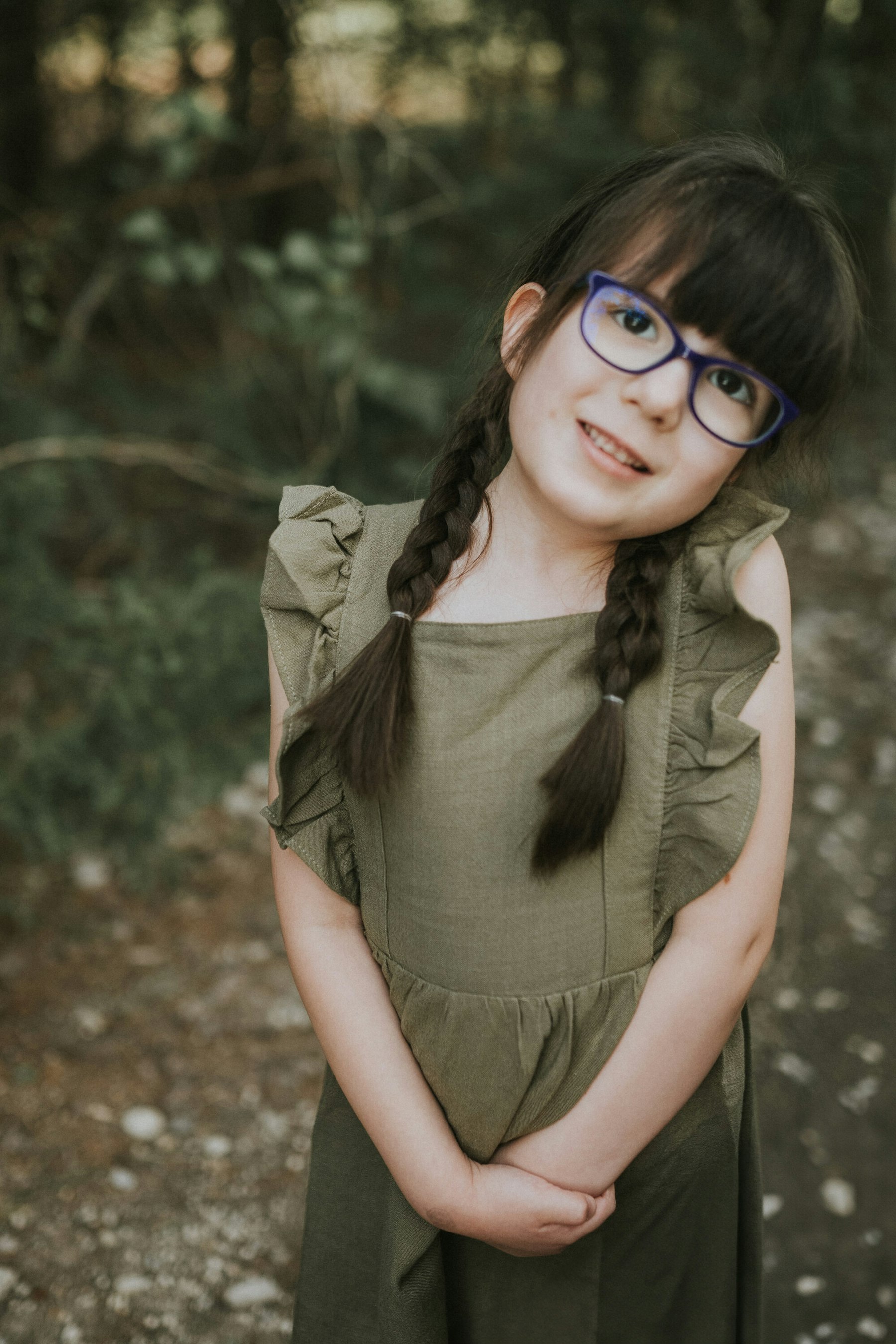 Girl in a green dress smiling on the path during a family session