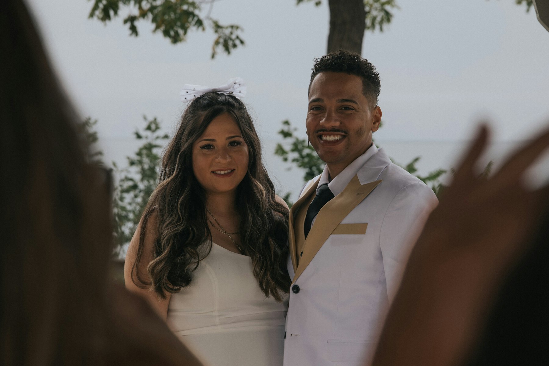 Bride and groom smiling together under a tree at a Veterans Memorial Park wedding in Avon Lake, Ohio