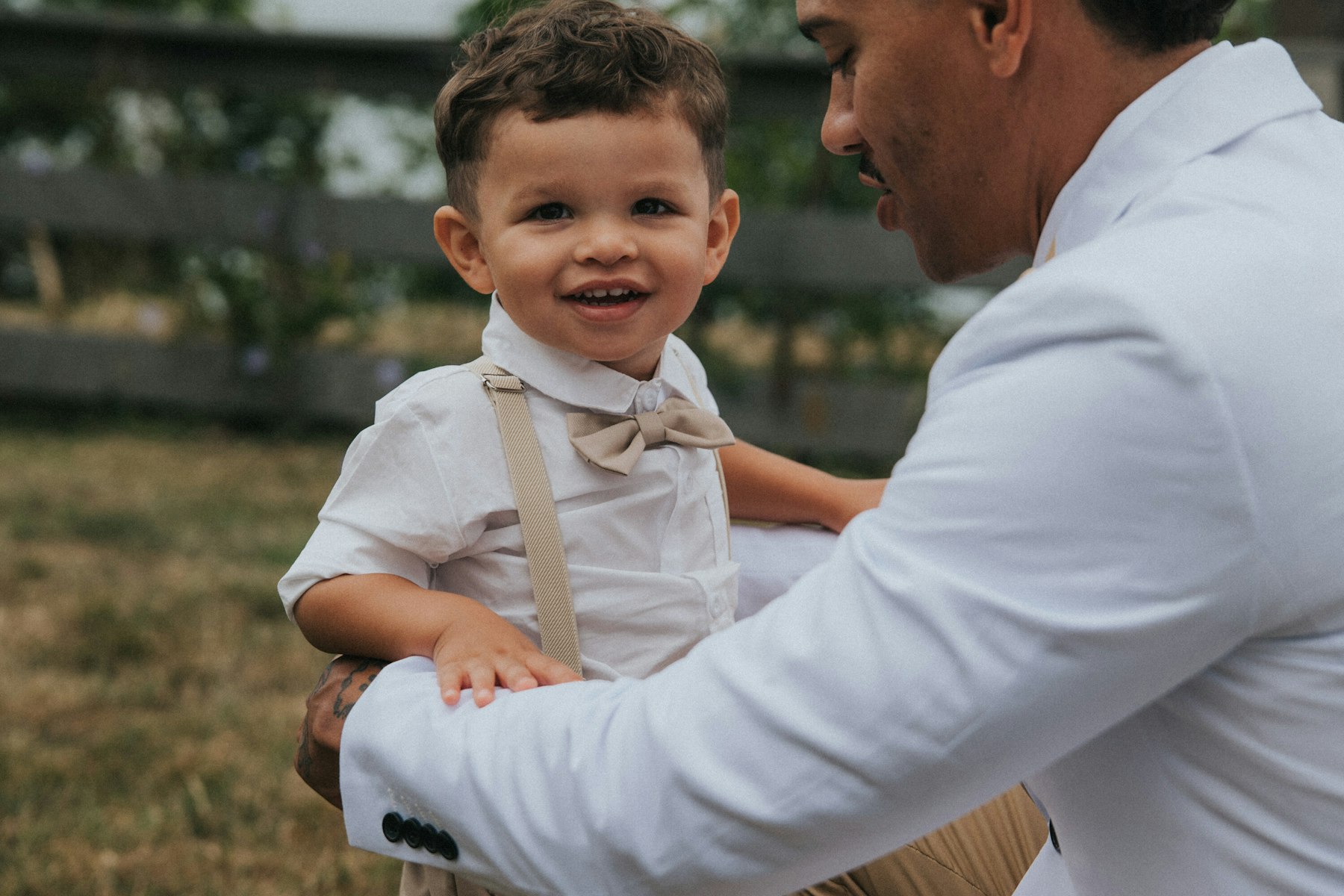 Groom holding his laughing toddler son at a Veterans Memorial Park wedding in Avon Lake, Ohio