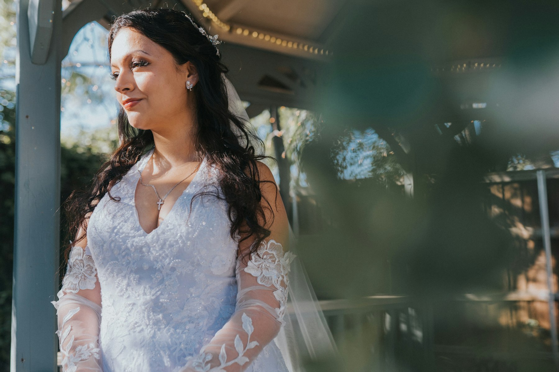 Bride under the gazebo in the sunlight at a garden wedding