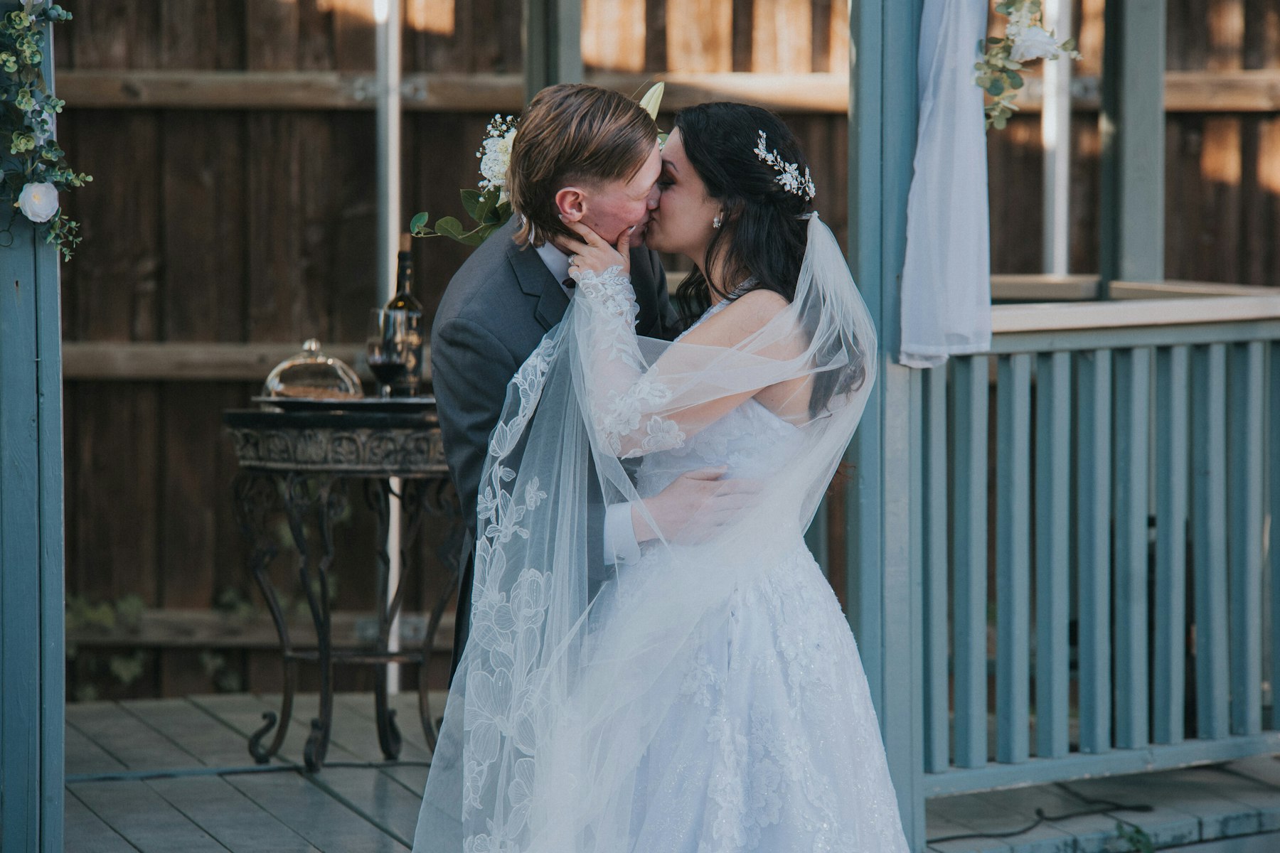 Bride and groom's first kiss on the porch at a garden wedding