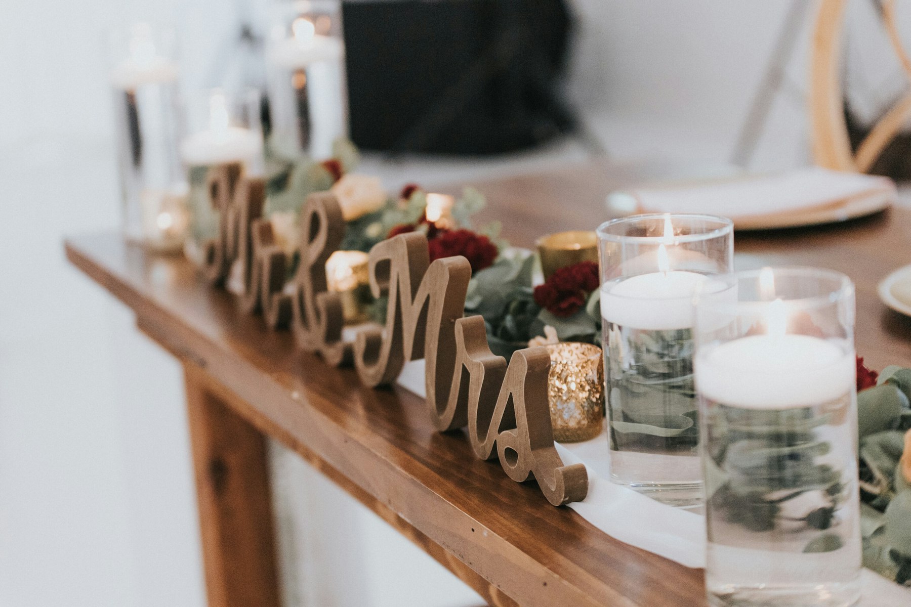 Sweetheart table with Mr and Mrs sign and candles at a white barn wedding