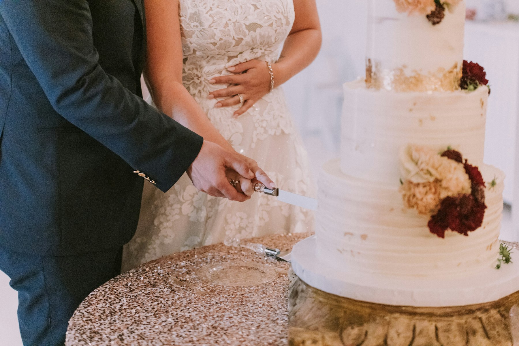 Bride and groom cutting the cake at a white barn wedding