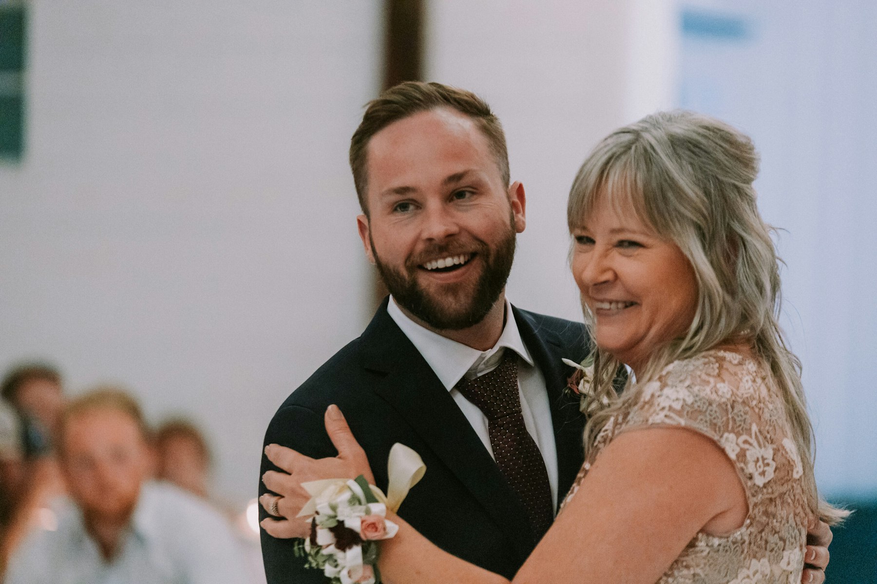 Groom dancing with his mother at a white barn wedding