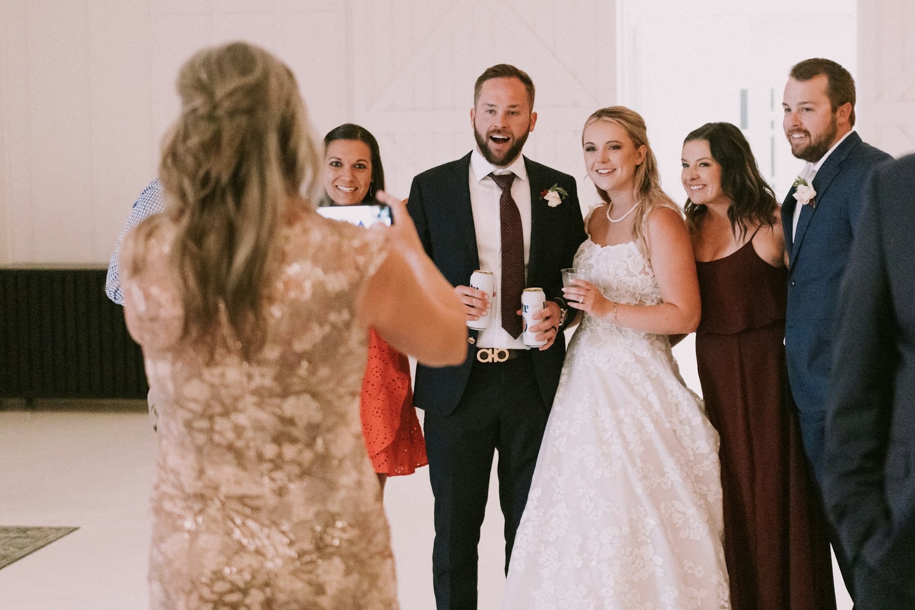 Bride and groom posing with guests at the reception at a white barn wedding