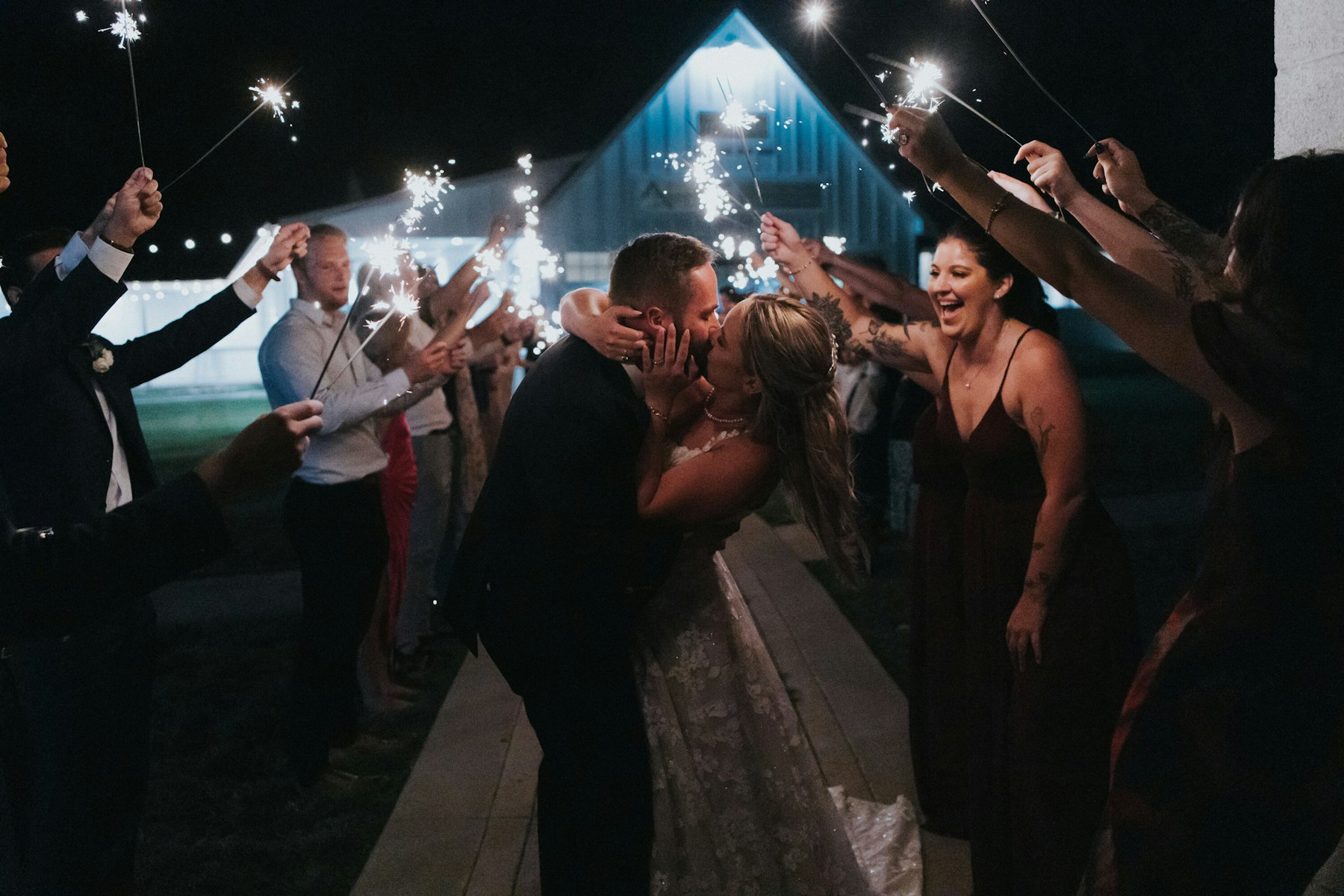 Sparkler exit kiss at a white barn wedding