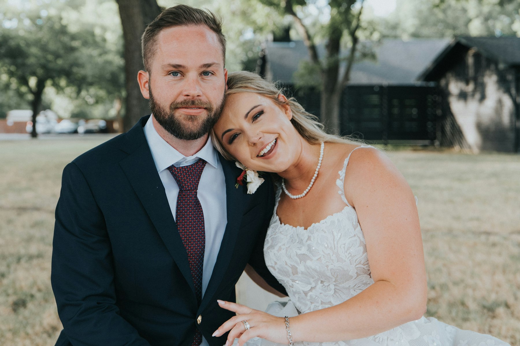 Bride and groom cheek to cheek at a white barn wedding