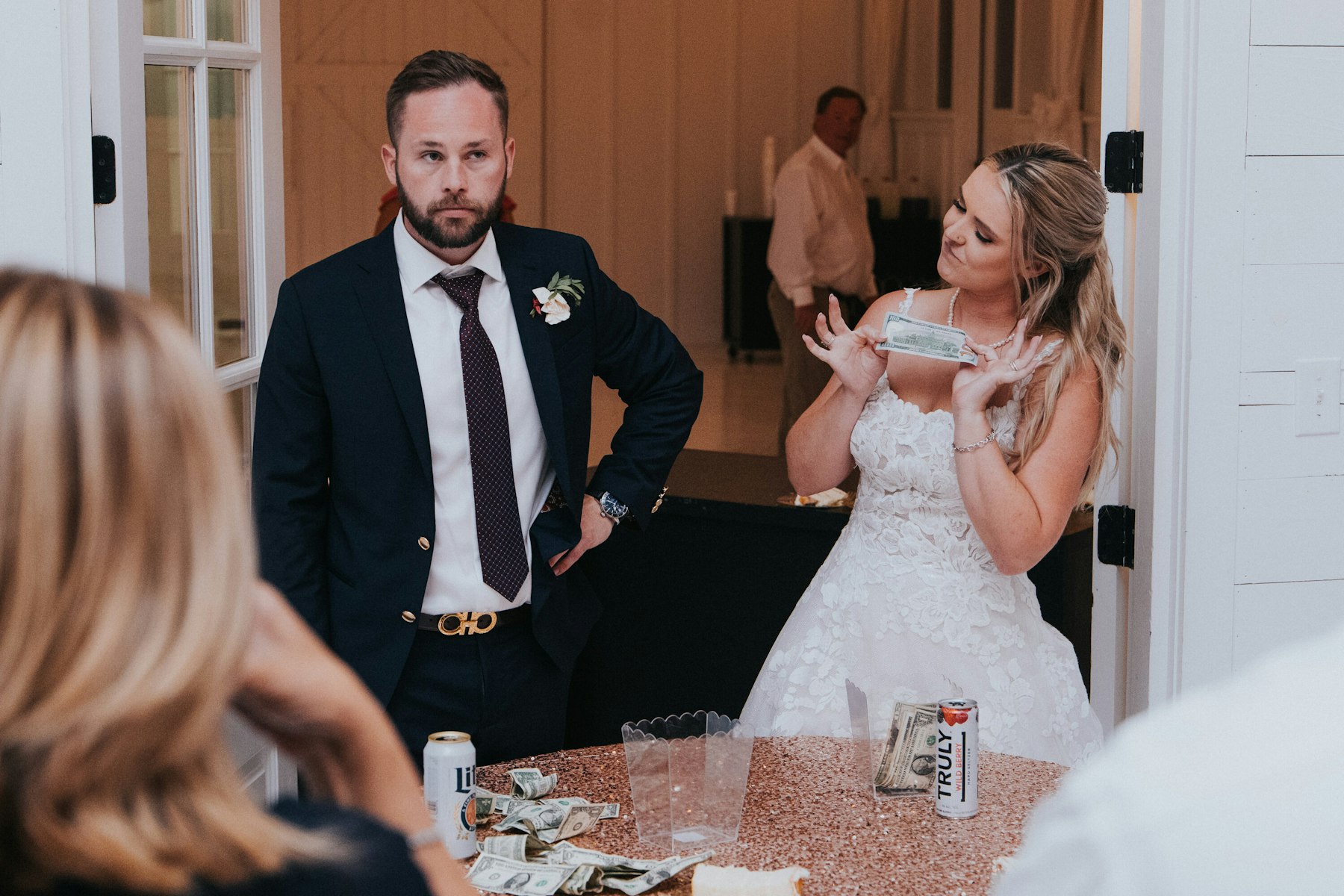 Bride and groom at the reception bar at a white barn wedding