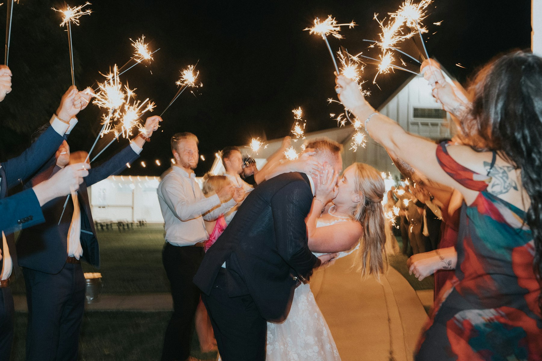 Sparkler send off kiss at a white barn wedding