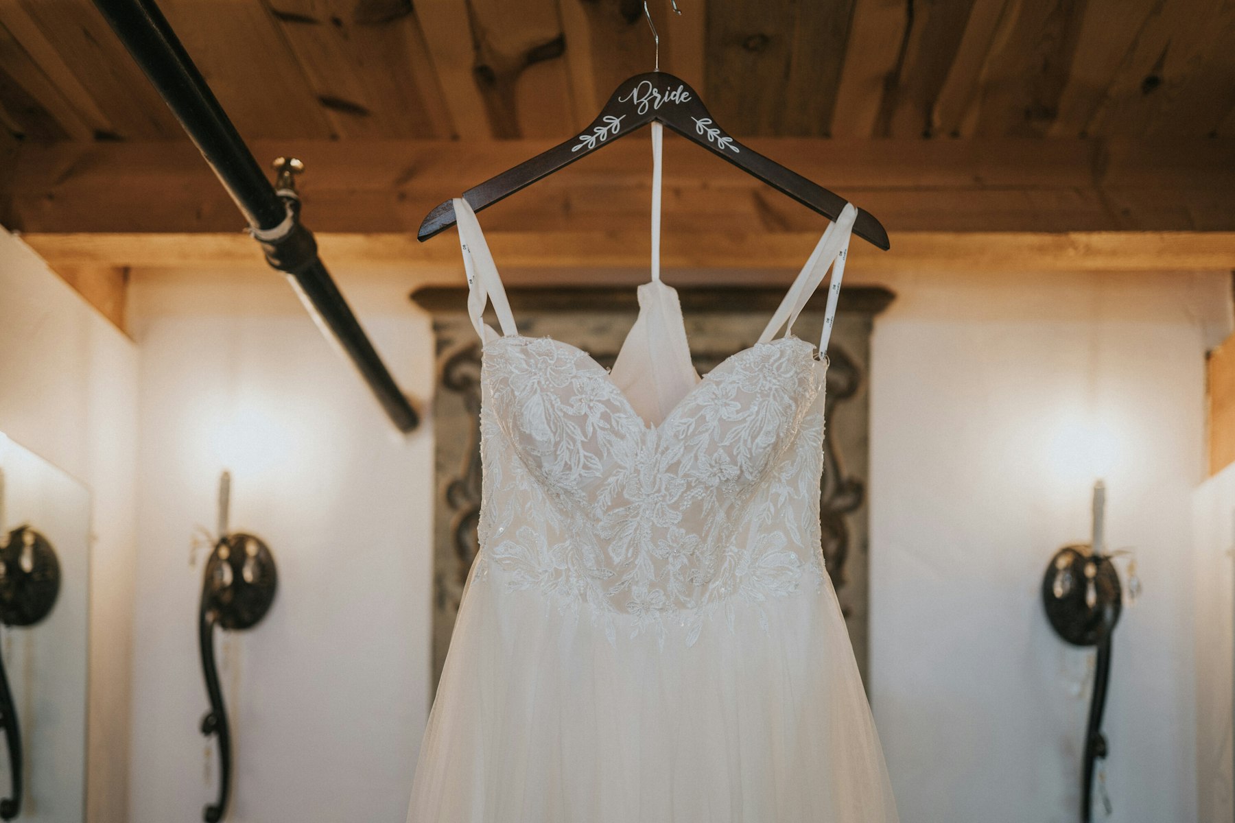 Wedding dress hanging in the barn at a rustic barn wedding