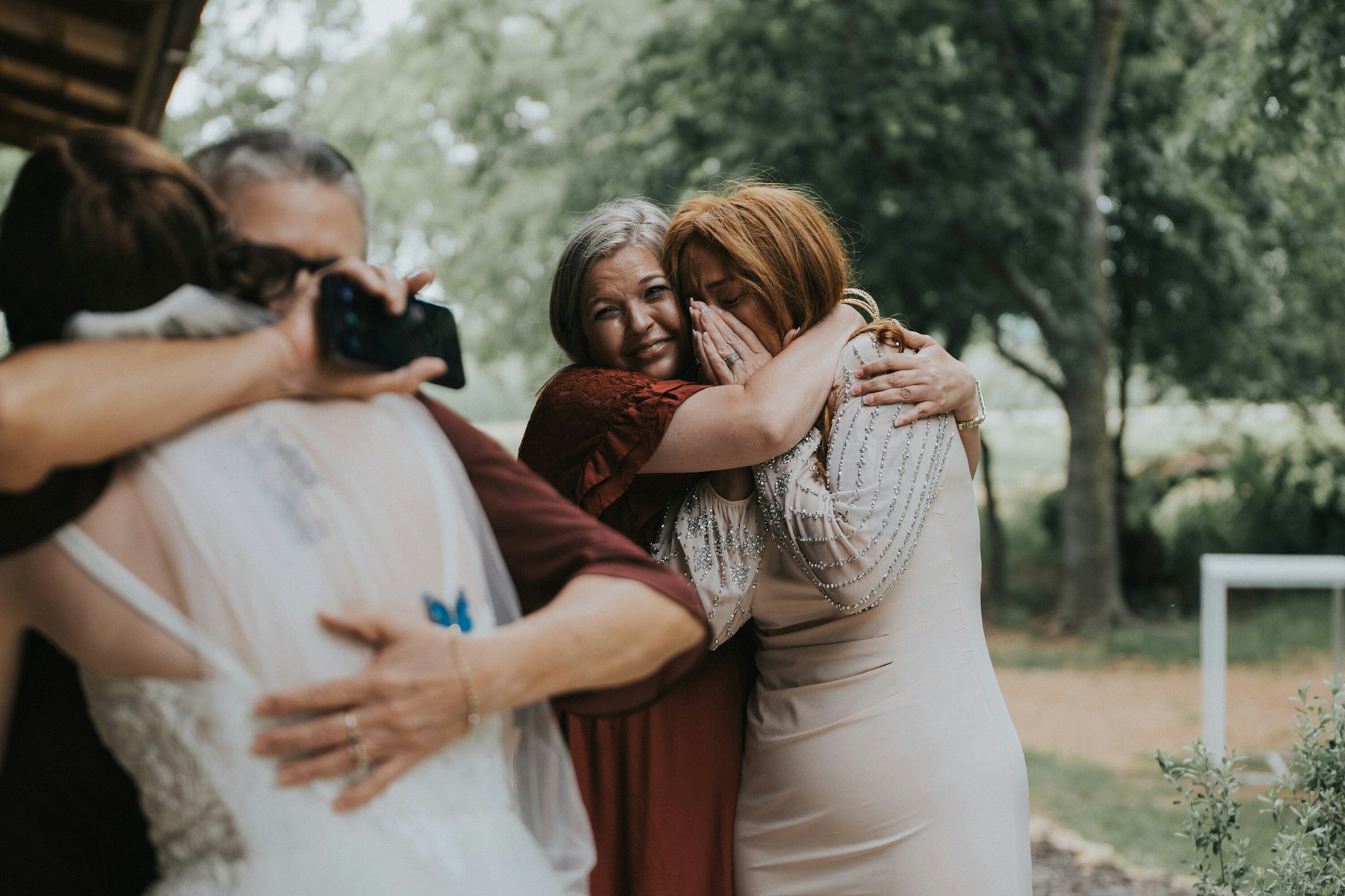 Bride hugging her family at a rustic barn wedding
