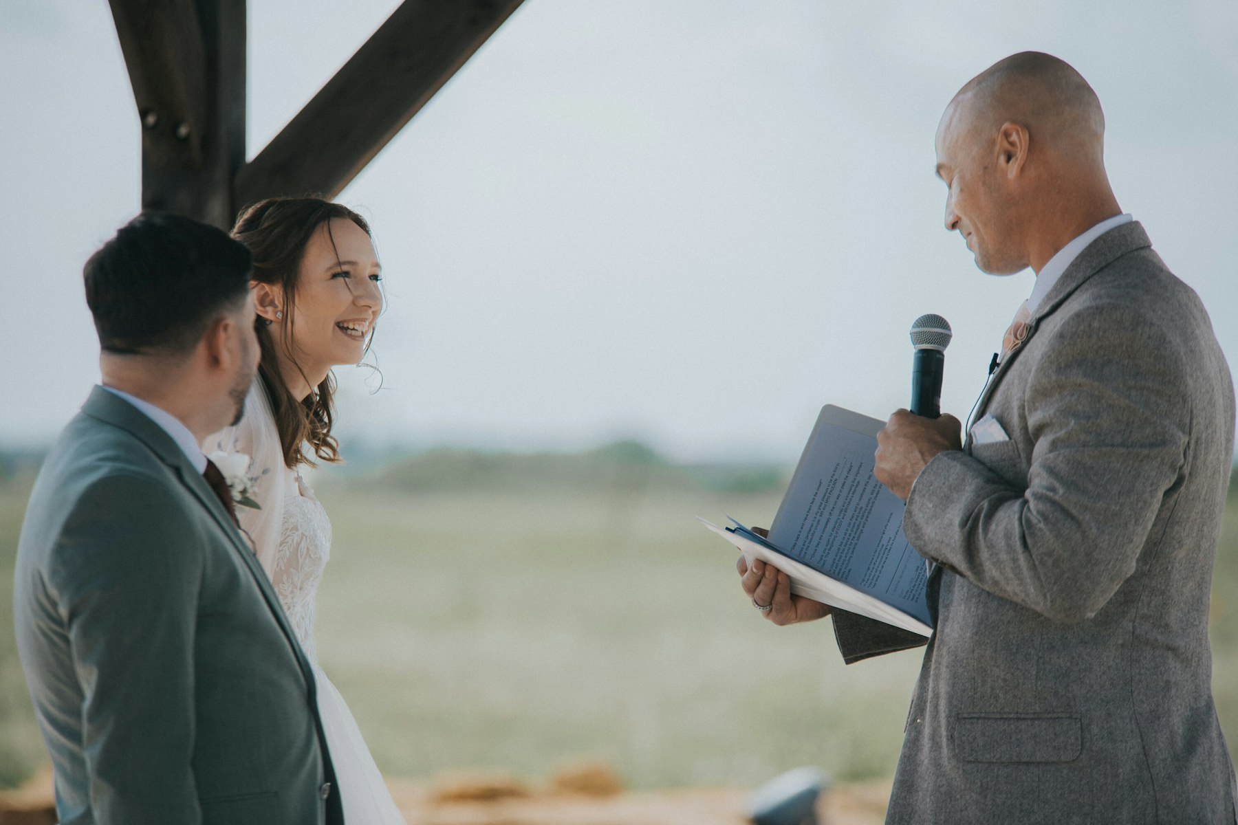 Officiant reading during the outdoor ceremony at a rustic barn wedding