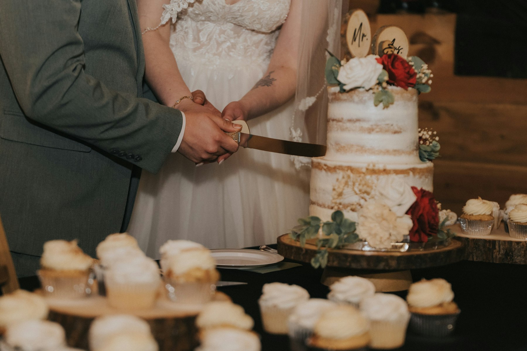 Bride and groom cutting the cake at a rustic barn wedding