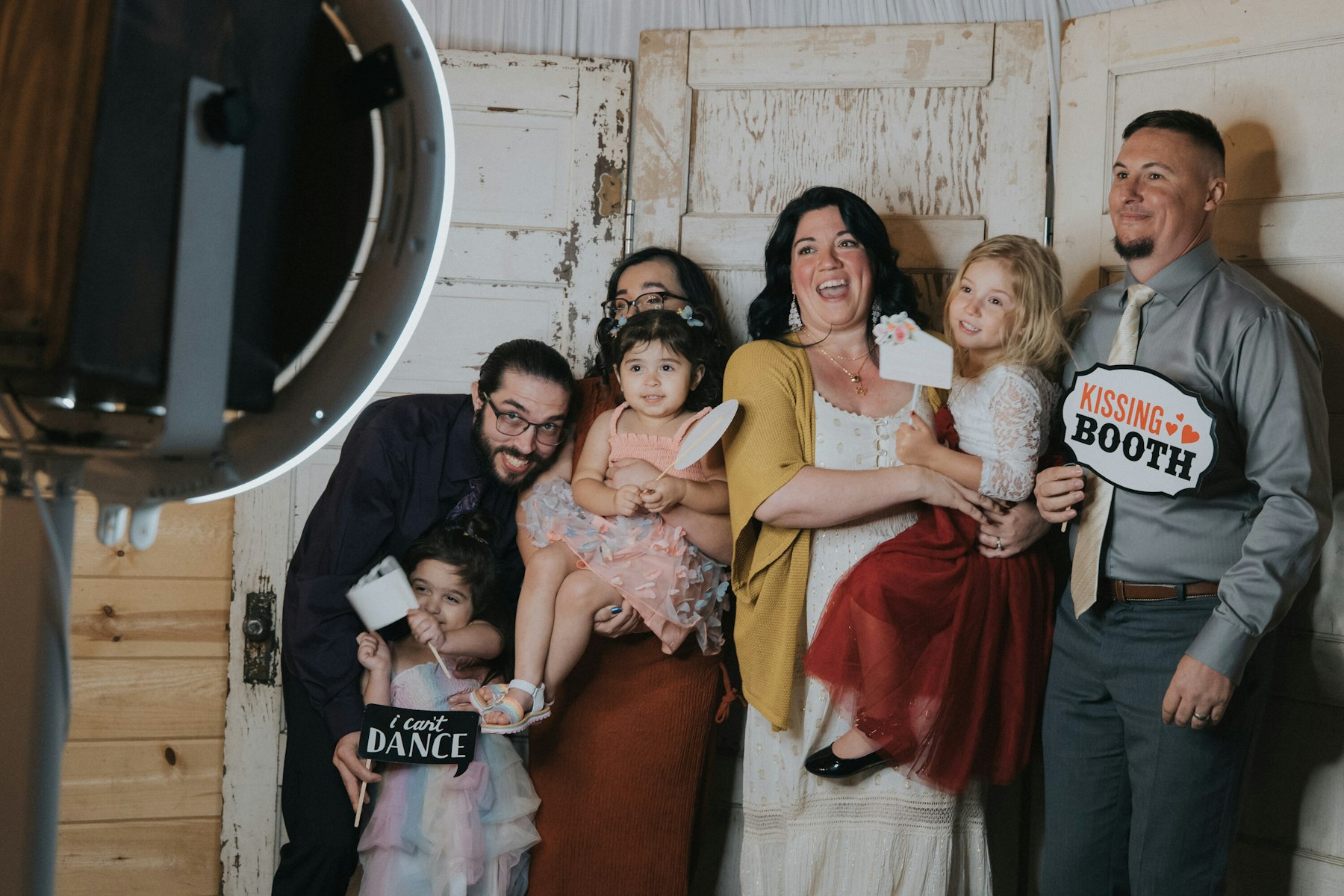 Photo booth fun with family at a rustic barn wedding