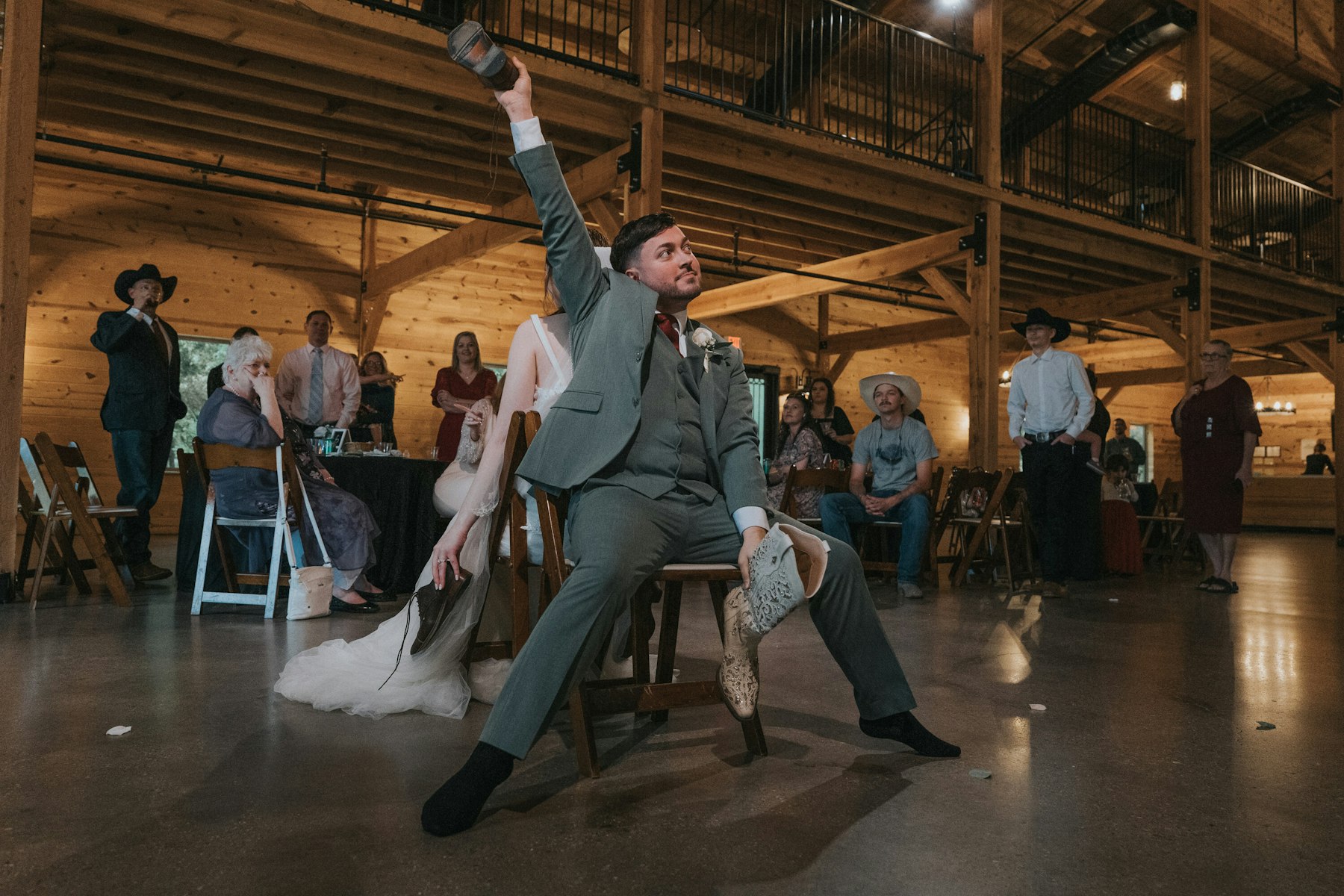 Groom celebrating on the dance floor at a rustic barn wedding