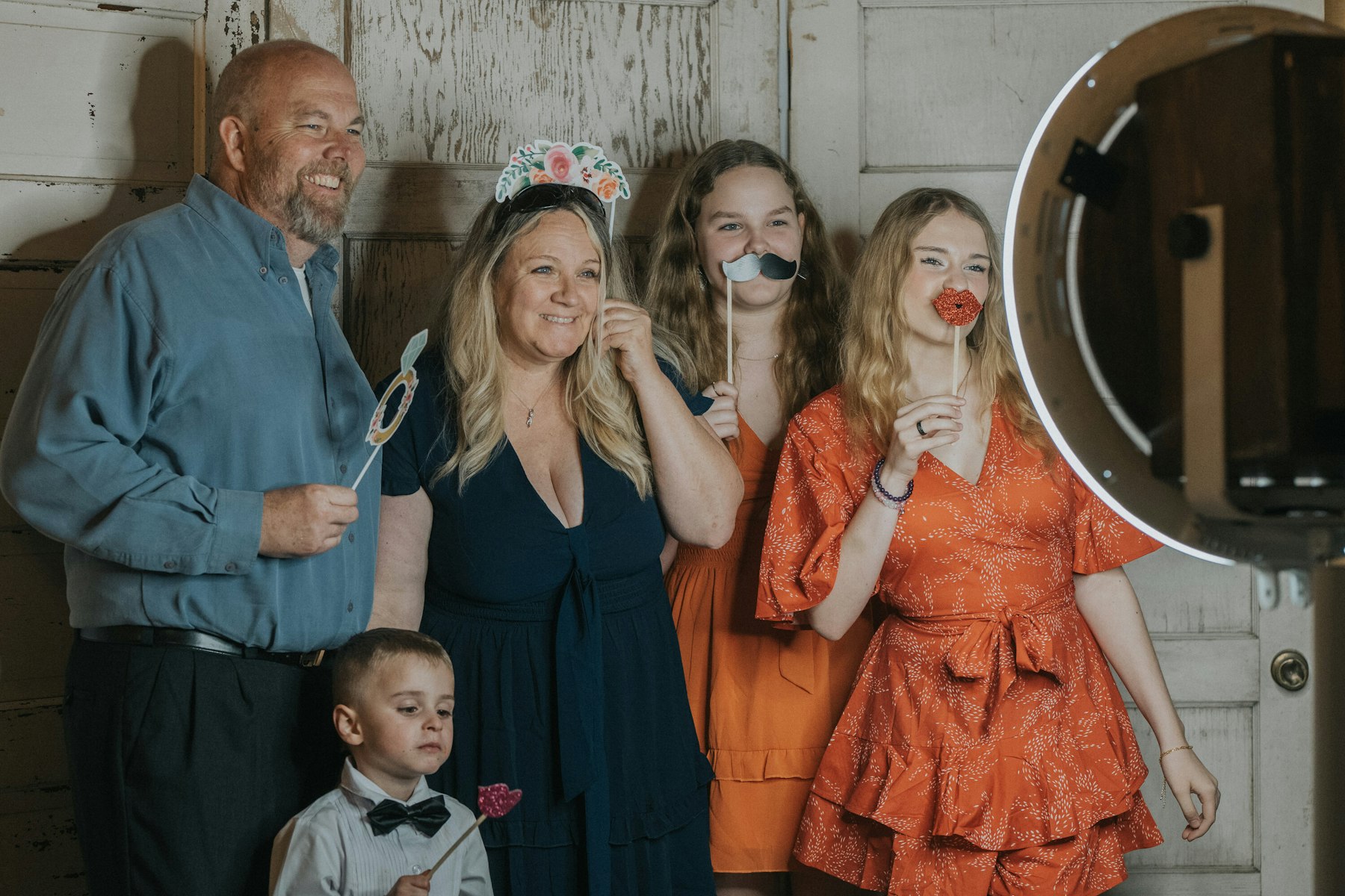 Family posing at the photo booth at a rustic barn wedding