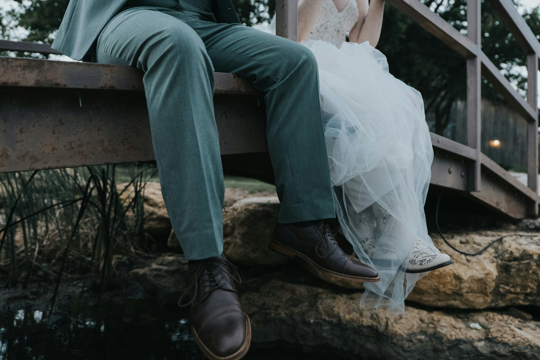Couple's boots on the rocks over the creek at a rustic barn wedding