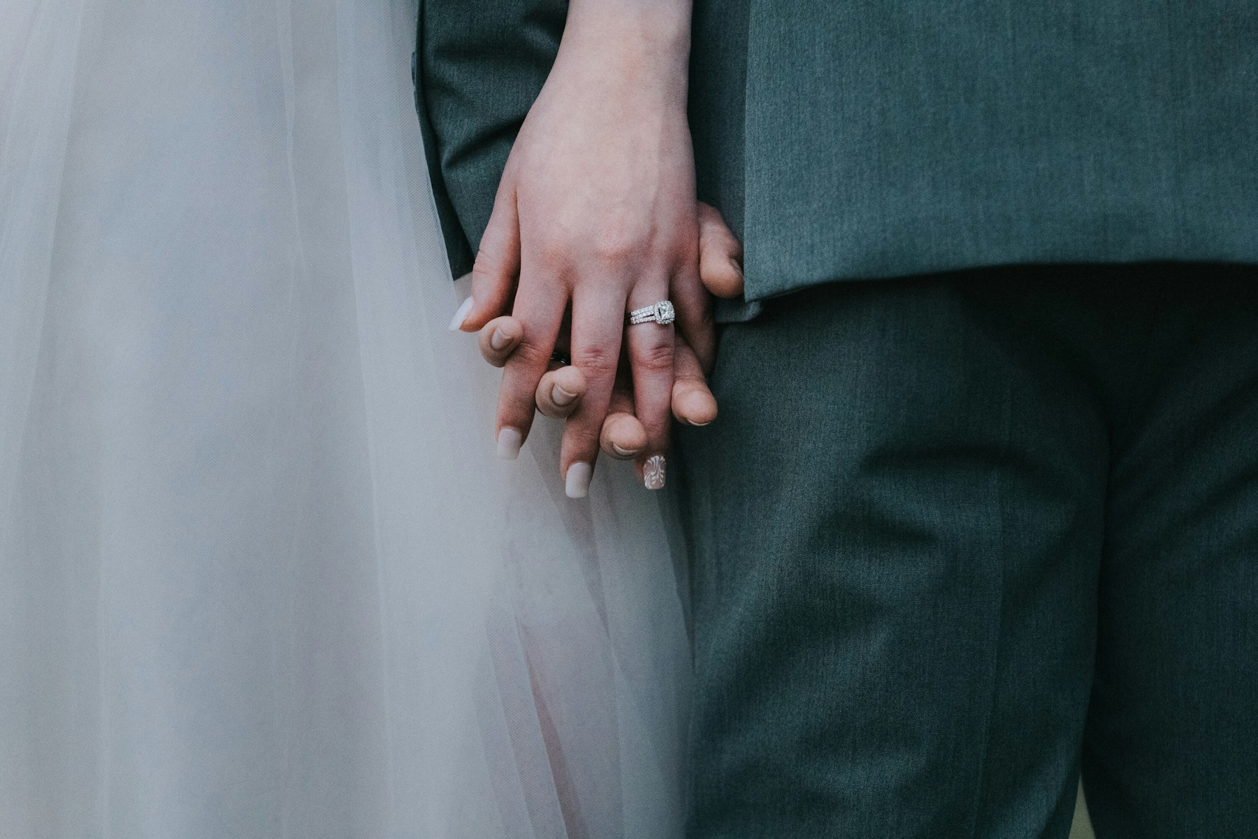 Holding hands, wedding ring close up at a rustic barn wedding