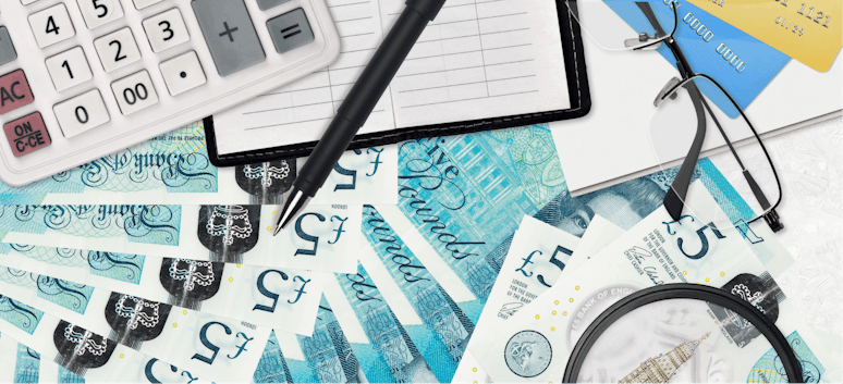 Blog hero image showing £5 notes, debit cards, a calculator, notebook and glasses