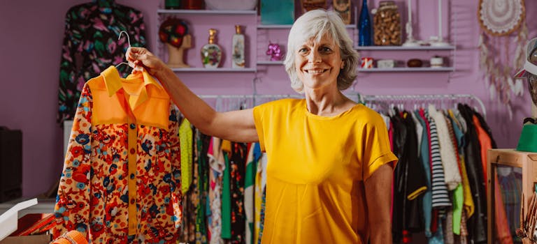 Woman in orange t-shirt holding up orange blouse