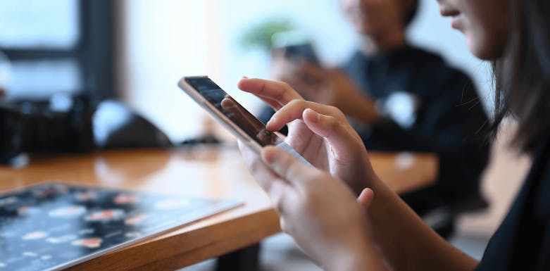 Woman playing phone game in a restaurant