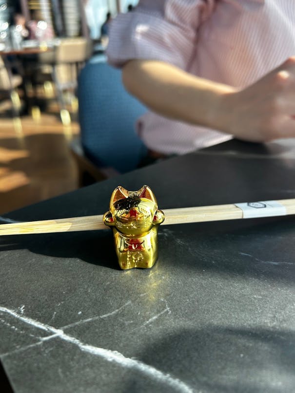 shiny gold cat chopstick holder on the table