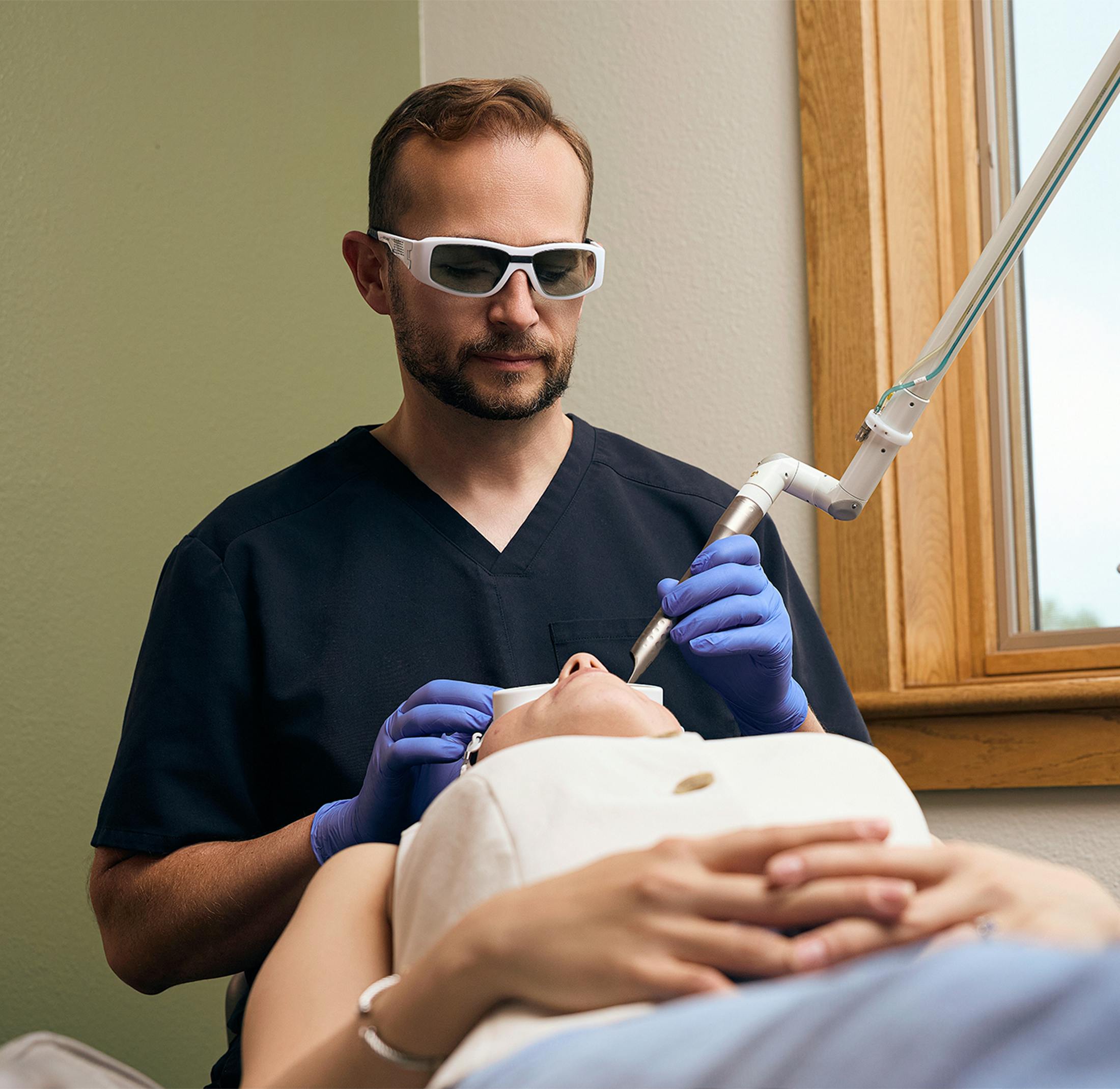 Dr preforming a laser treatment