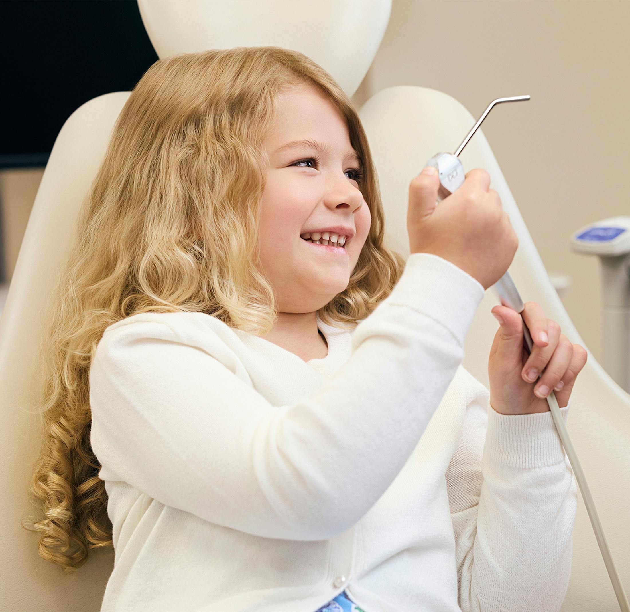 child holding dental instrument